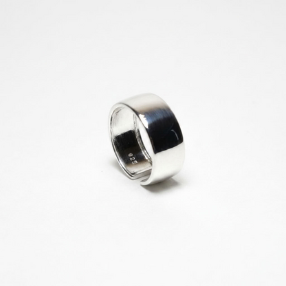 A polished sterling silver band ring with a smooth, slightly tapered cylindrical shape, standing upright on a clean white background.